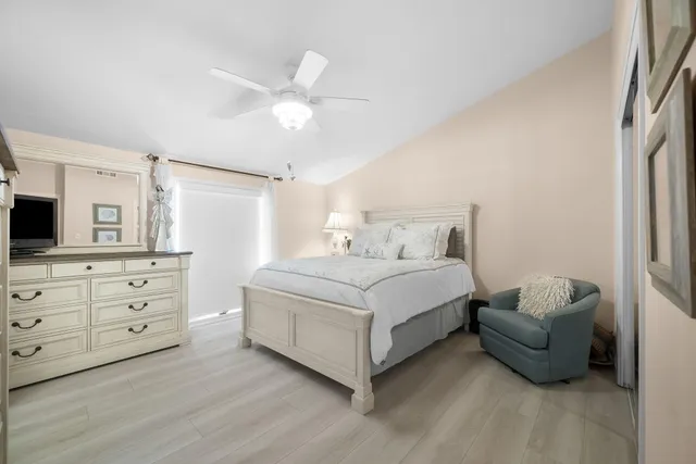 a bedroom with a large bed and a chandelier
