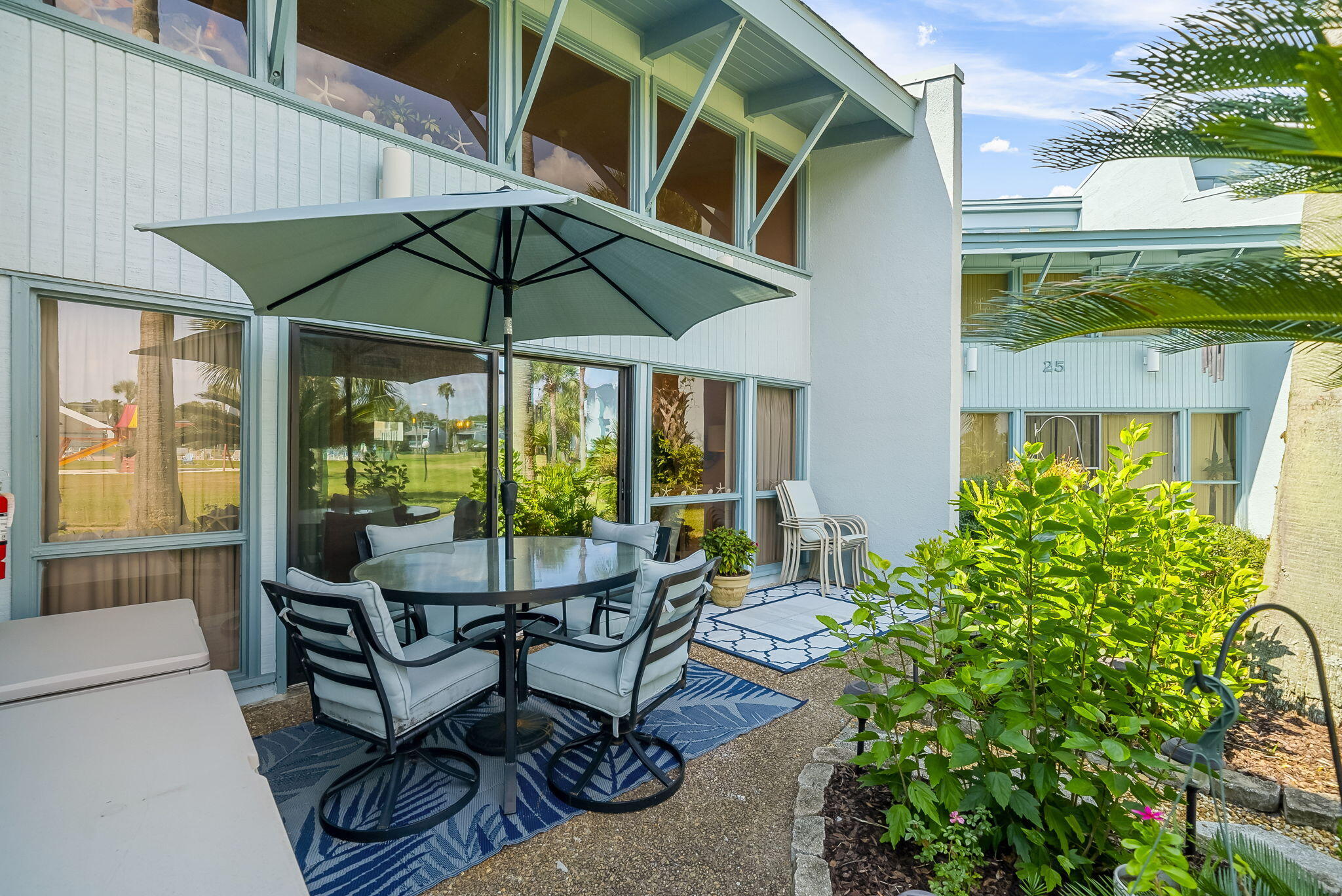 22400 Front Beach Road, Unit 24 Panama City Beach, FL 32413 - Photo 31 of 41 a view of a patio with table and chairs under an umbrella