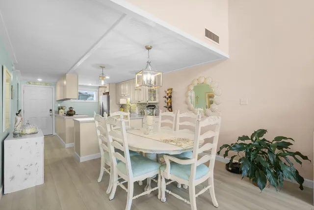 a large white kitchen with a refrigerator a stove and white cabinets