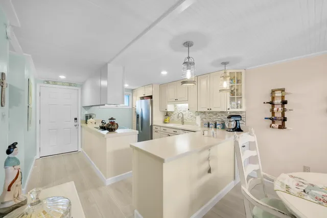 a kitchen with stainless steel appliances white cabinets and a refrigerator