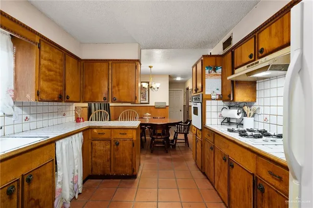 a large kitchen with stainless steel appliances a sink counter space and a window