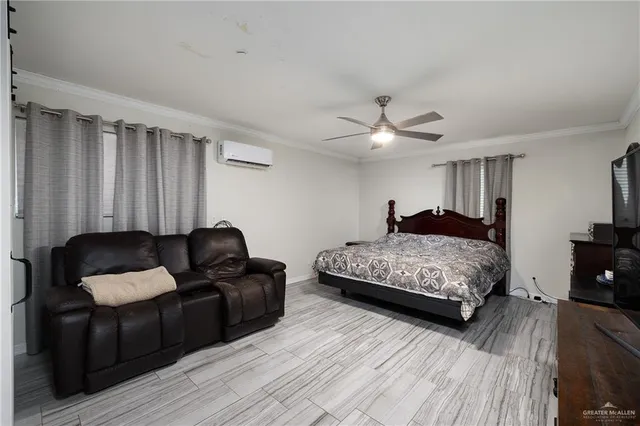 a bedroom with a bed couch and a ceiling fan
