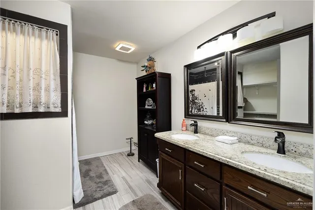 a bathroom with a granite countertop sink and a mirror