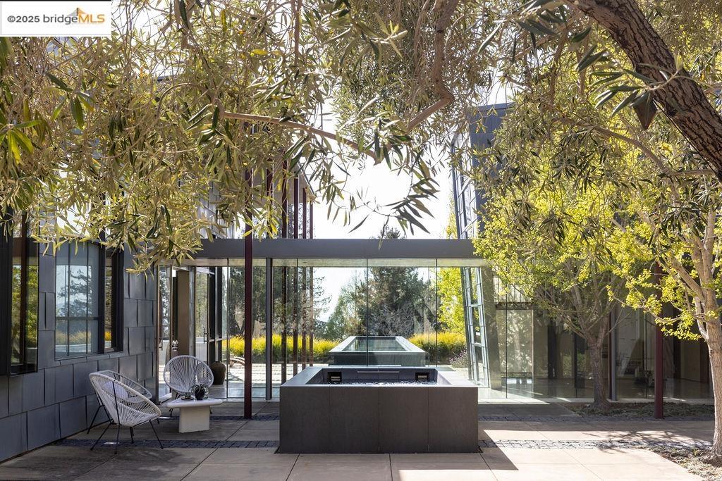a view of a patio with table and chairs and floor to ceiling window