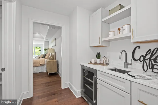a kitchen with white cabinets and sink