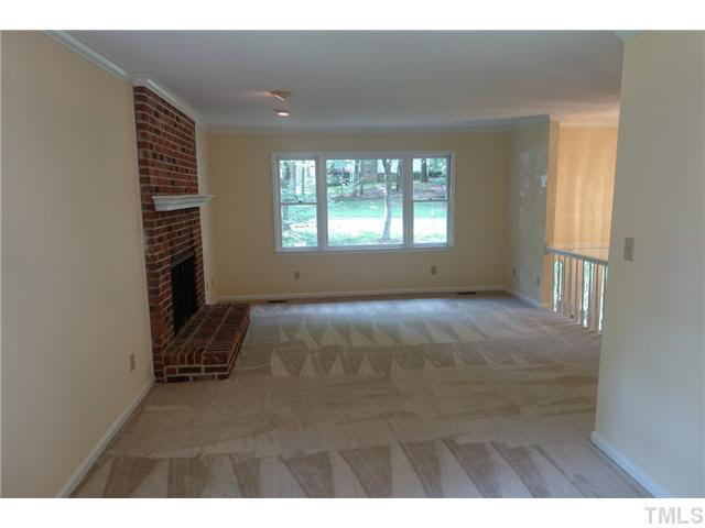 7124 Mill Ridge Road Raleigh, NC 27613 - Photo 3 of 23 Open living room with plenty of natural light, wood burning brick surround fireplace, mantle & recessed lights.