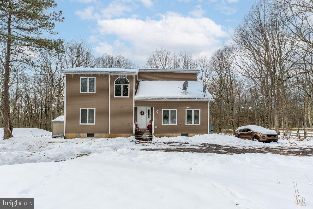 a front view of a house with a yard covered in snow