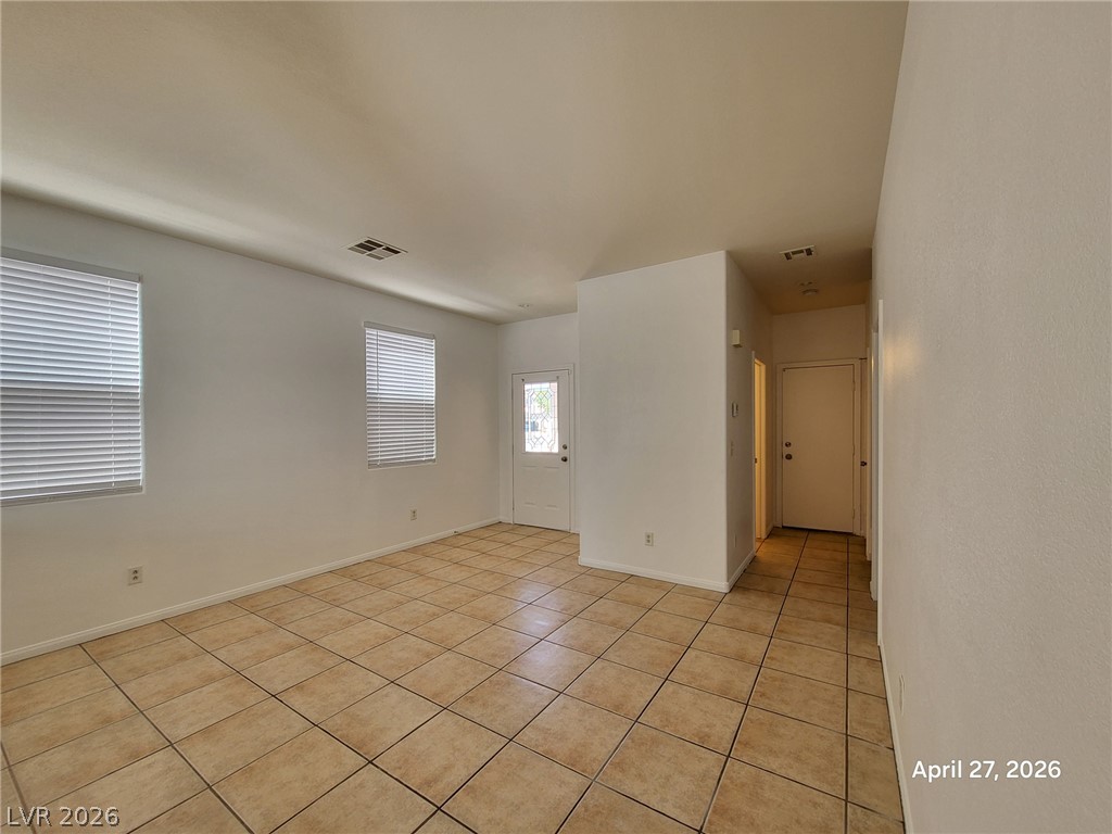 4548 Flaming Ridge Trail Las Vegas, NV 89147 - Photo 3 of 21 Tiled flooring and natural light through multiple windows define this open living space.
