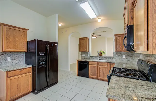 a kitchen with stainless steel appliances granite countertop a refrigerator and a stove top oven