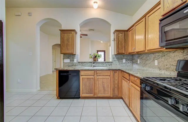 a kitchen with stainless steel appliances granite countertop a stove a sink and a microwave