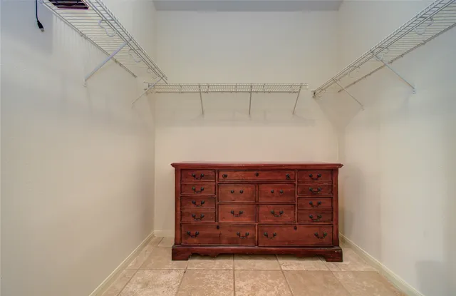 a view of walk in closet with empty racks
