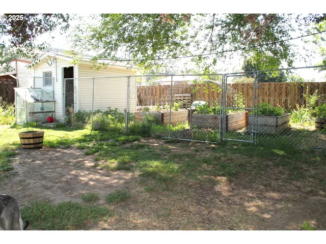 a backyard of a house with barbeque oven fire pit table and chairs