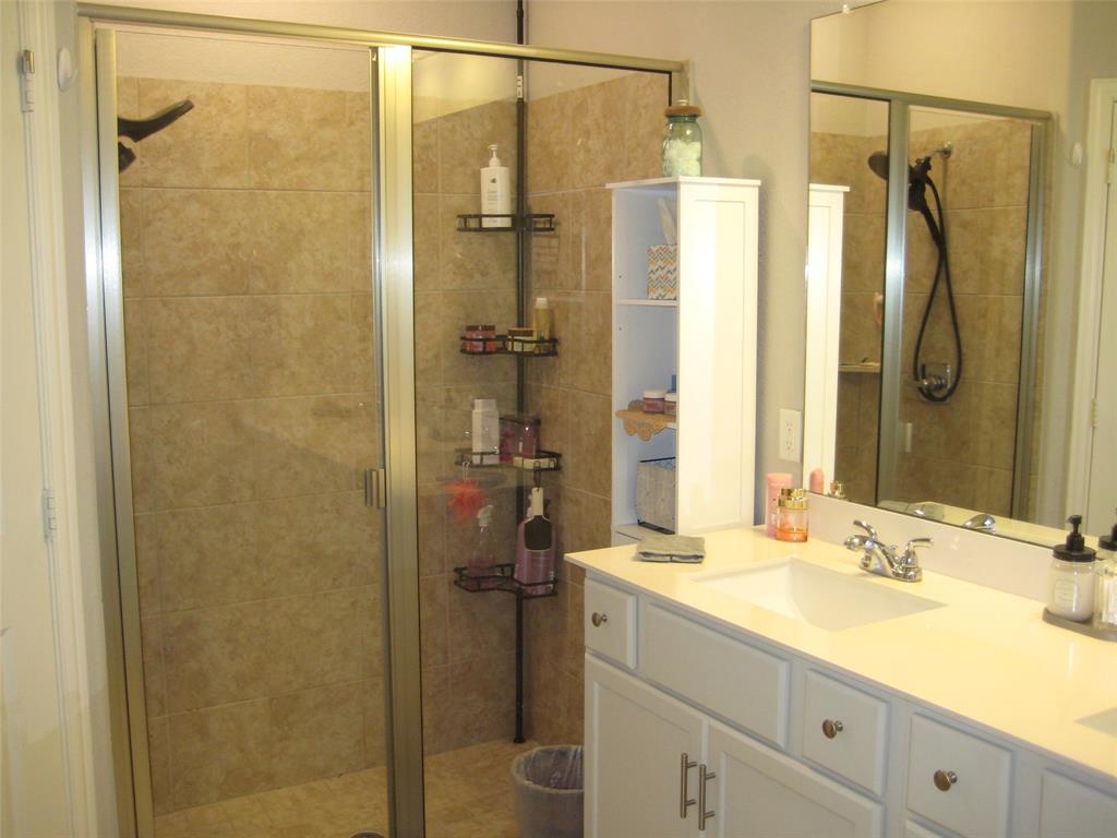 2 Grouse Run Sanger, TX 76266 - Photo 11 of 26 a bathroom with a granite countertop shower sink vanity and a mirror