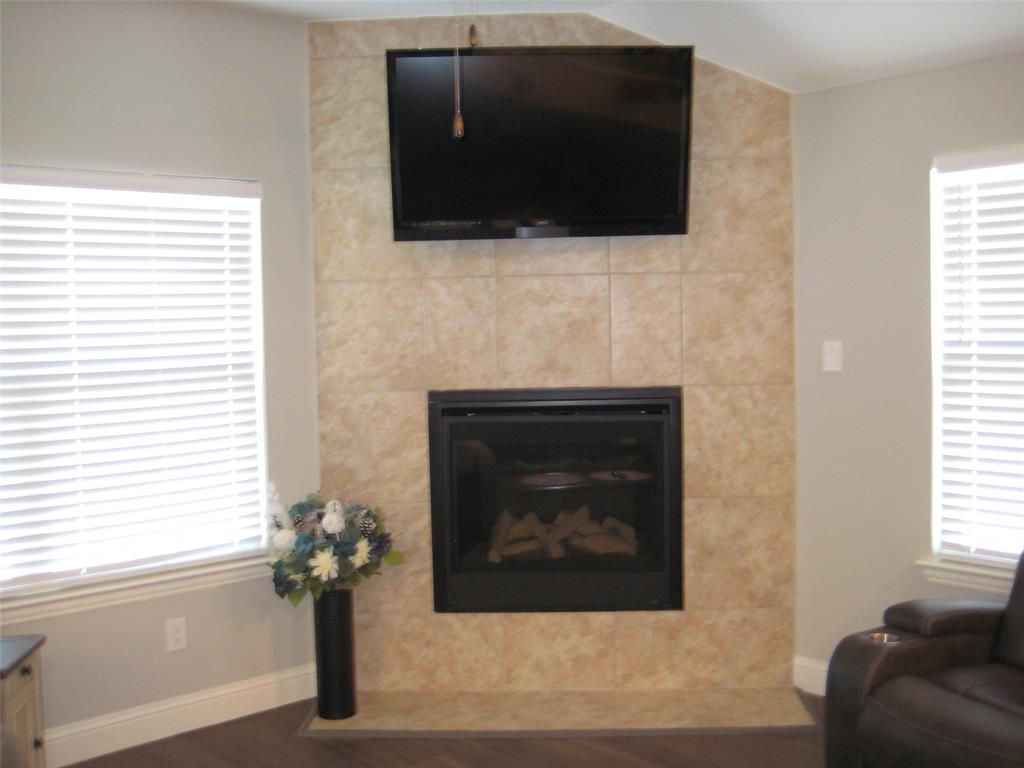 2 Grouse Run Sanger, TX 76266 - Photo 2 of 26 a living room with a fireplace and a flat screen tv