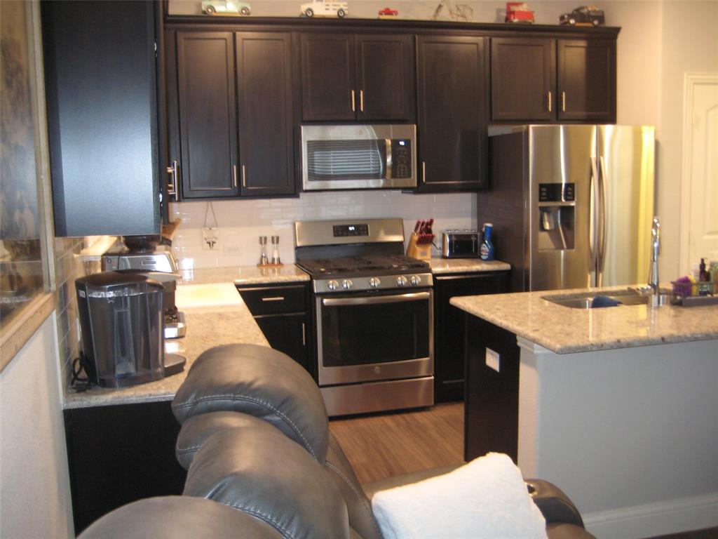 2 Grouse Run Sanger, TX 76266 - Photo 4 of 26 a kitchen with granite countertop a sink stove and refrigerator
