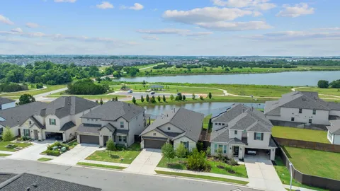 an aerial view of residential houses with outdoor space and lake view