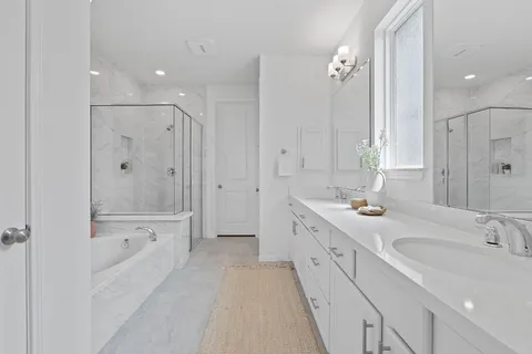 a spacious bathroom with a bathtub shower sink double and mirror