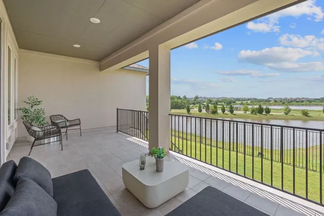 a balcony with chairs and a potted plant