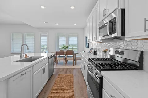 a kitchen with stainless steel appliances a sink stove and cabinets