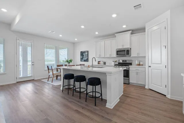 a kitchen with a sink stainless steel appliances and white cabinets