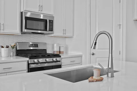 a kitchen with stainless steel appliances granite countertop a stove and a microwave