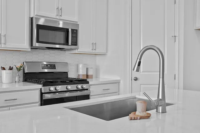 a kitchen with stainless steel appliances granite countertop a stove and a microwave