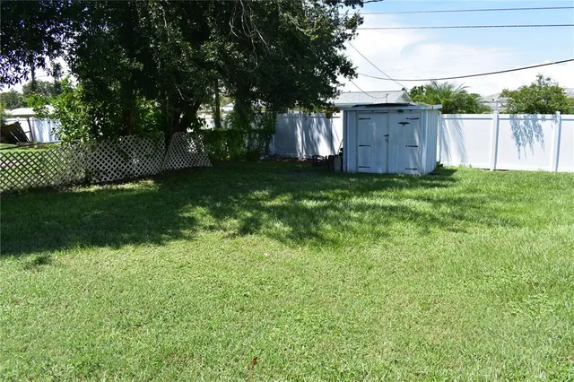 a view of a backyard with large trees and a barn