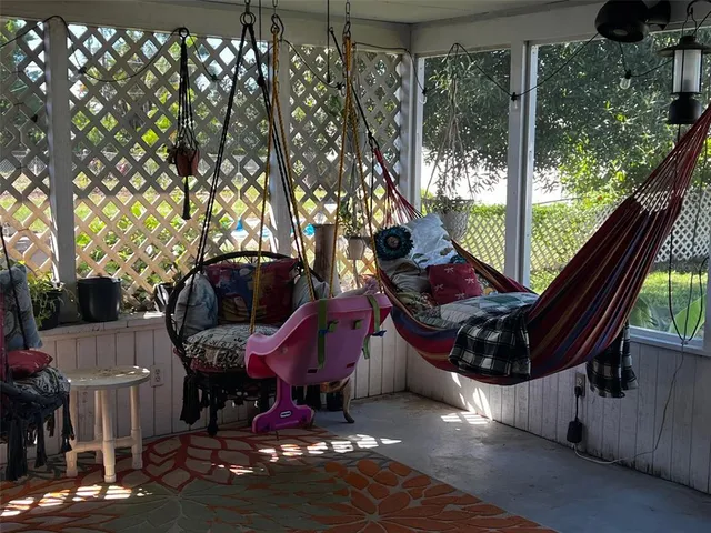a living room with furniture a rug and a floor to ceiling window
