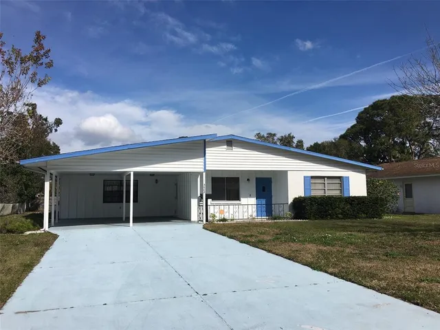 a view of house with a yard and potted plants