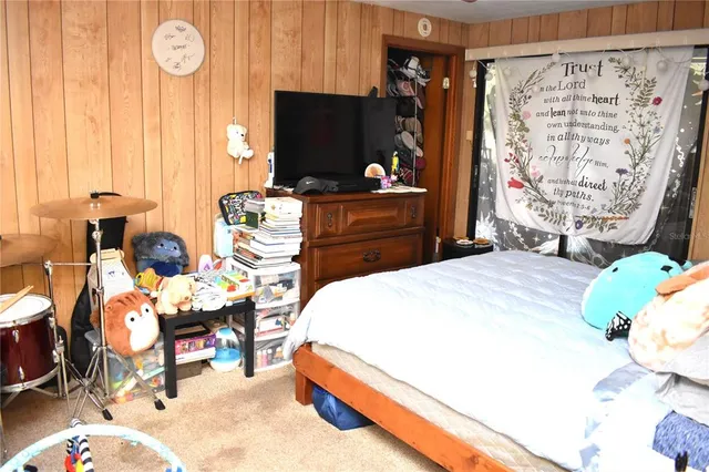 a bedroom with a bed and a flat tv screen