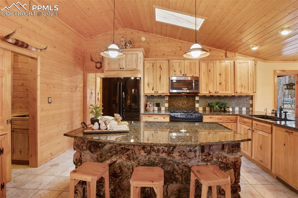 265 Broken Wheel Drive Divide, CO 80814 - Photo 3 of 50 a kitchen with a dining table chairs sink and cabinets