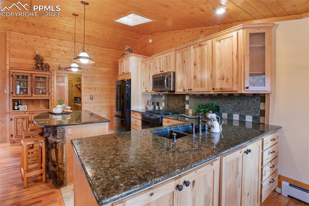 265 Broken Wheel Drive Divide, CO 80814 - Photo 5 of 50 a kitchen with stainless steel appliances granite countertop a sink a stove counter space and cabinets