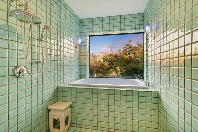 a bathroom with a granite countertop sink a mirror and a shower