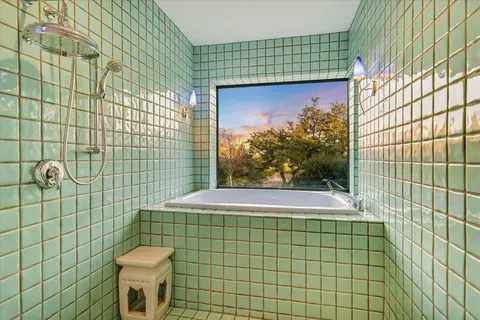 a bathroom with a granite countertop sink a mirror and a shower