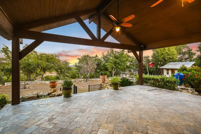 a view of a porch with a table and chairs under an umbrella