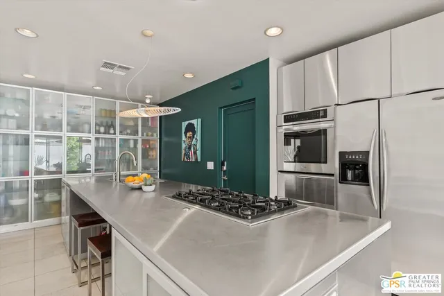 a kitchen with stainless steel appliances a sink a stove and a refrigerator