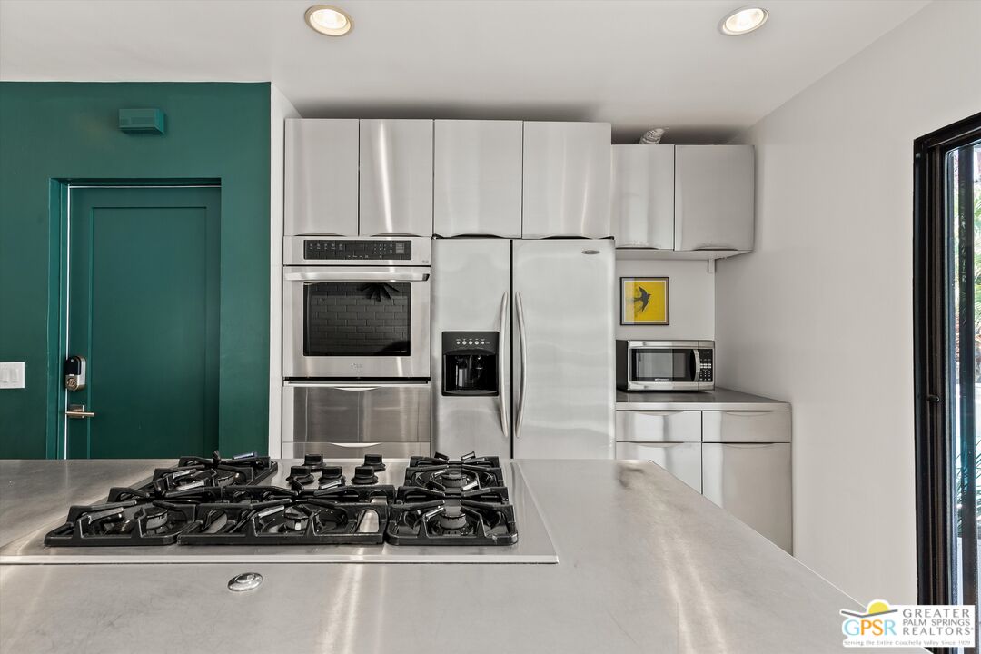1465 North Rodeo Road Palm Springs, CA 92262 - Photo 16 of 43 a kitchen with wooden cabinets and a stove top oven