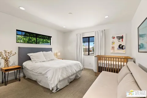 a bedroom with a bed and a dresser with rug