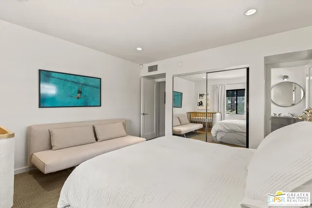 a bedroom with a large bed and a flat screen tv