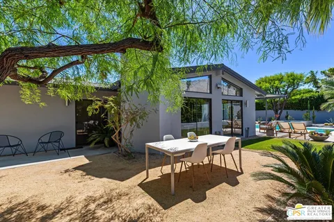 a view of a backyard with a patio and outdoor seating