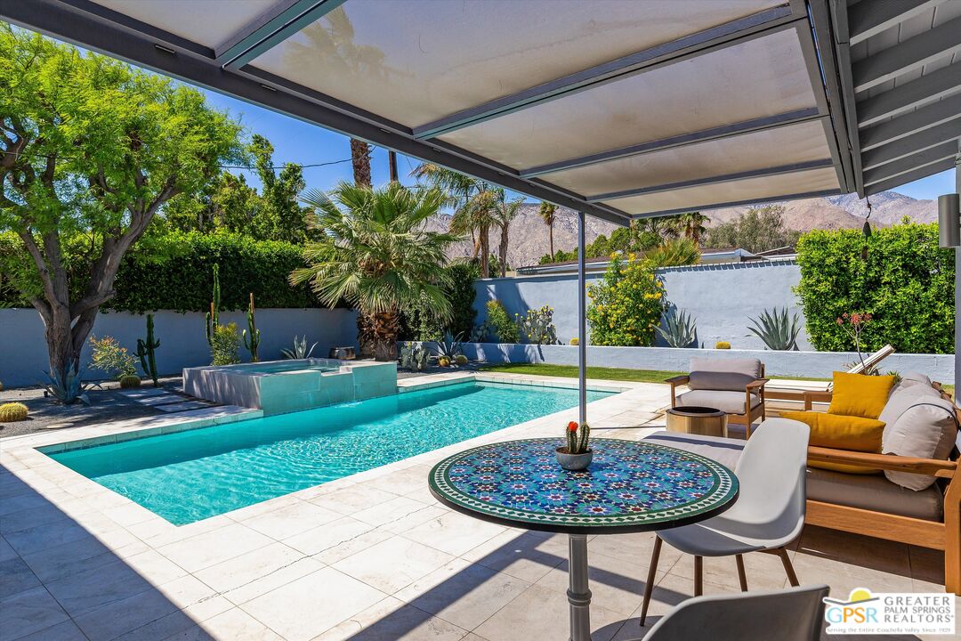 1465 North Rodeo Road Palm Springs, CA 92262 - Photo 42 of 43 a view of a backyard with table and chairs potted plants and a large tree