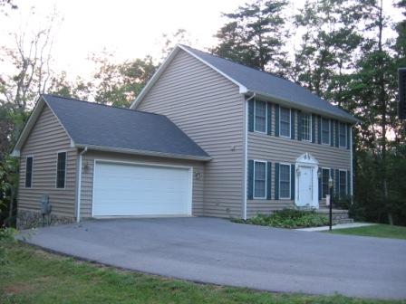 a front view of a house with a garden and garage