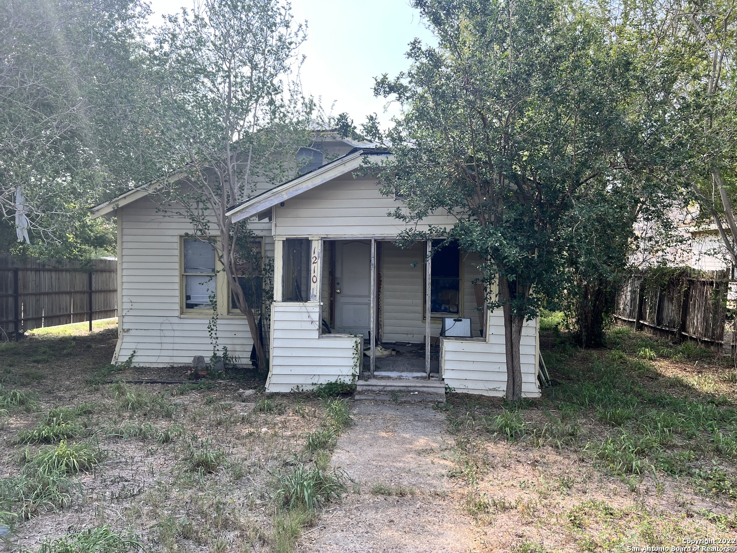 a view of a house with a yard and tree