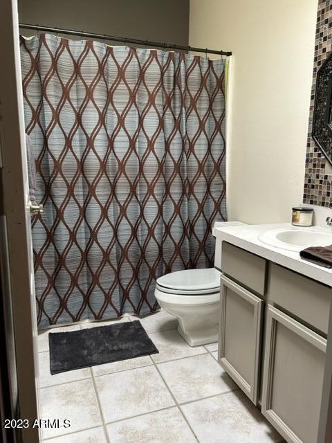 1172 West Mountain View Green Valley, AZ 85622 - Photo 24 of 35 a bathroom with a sink a toilet and a shower curtain