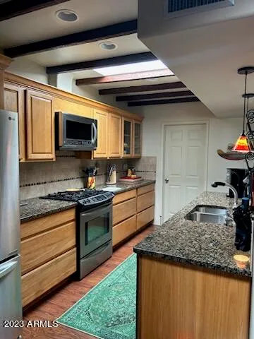 a kitchen with kitchen island granite countertop a stove cabinets and microwave
