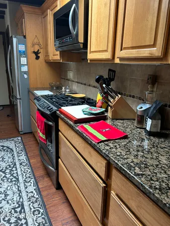 a kitchen with stainless steel appliances granite countertop a stove and a microwave