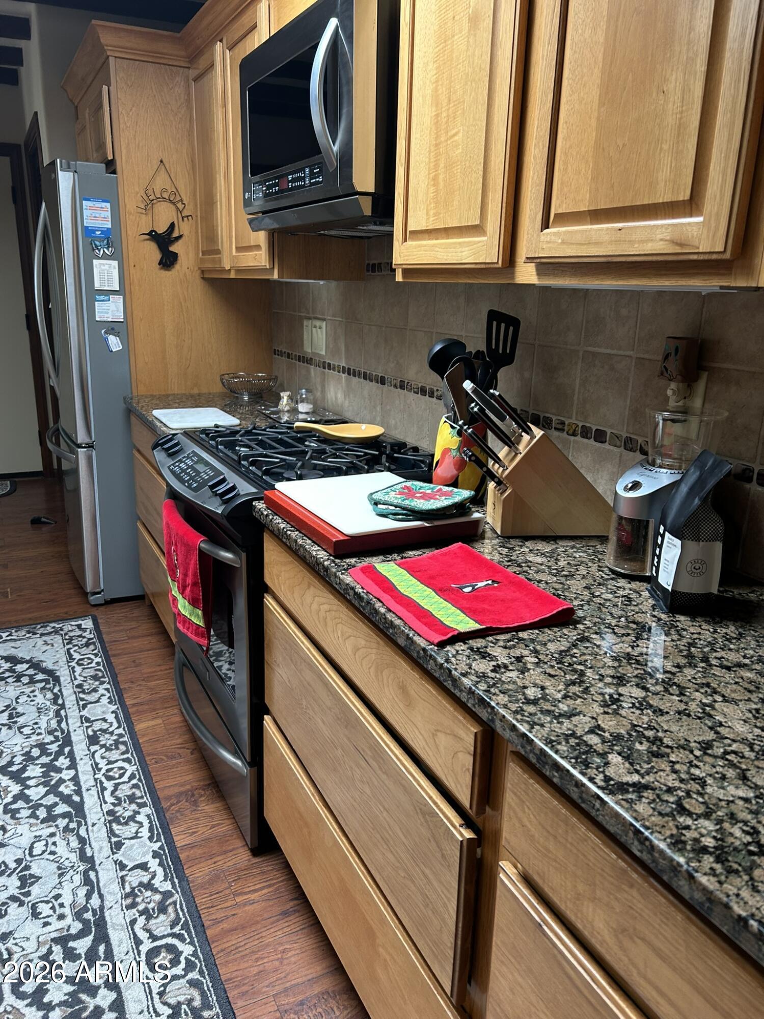 1172 West Mountain View Green Valley, AZ 85622 - Photo 4 of 35 a kitchen with stainless steel appliances granite countertop a stove and a microwave