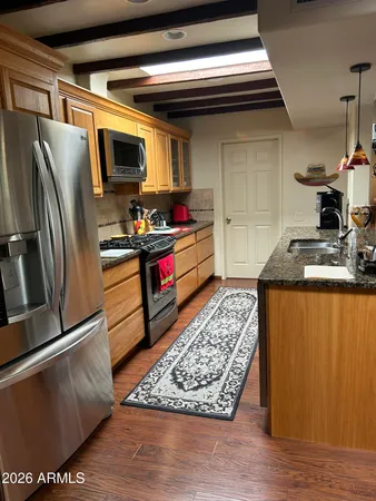 a kitchen with stainless steel appliances granite countertop a stove a sink and a refrigerator