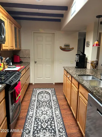 a kitchen with granite countertop stainless steel appliances and wooden cabinets