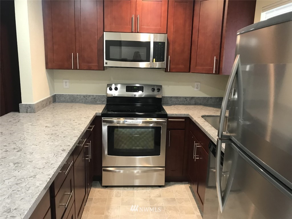 115 Union Avenue Northeast Renton, WA 98059 - Photo 9 of 20 a kitchen with a stove and a microwave